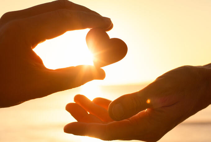 Herz wird von einer Hand in die andere gegeben (Foto: iStock/Kieferpix)